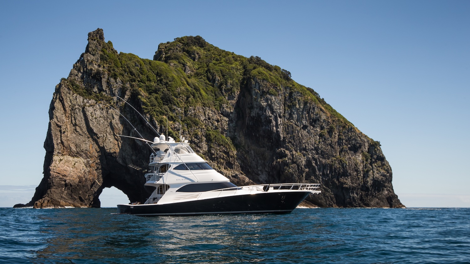 Luxury yacht Ata Rangi cruising beside the Hole in the Rock in the Bay of Islands