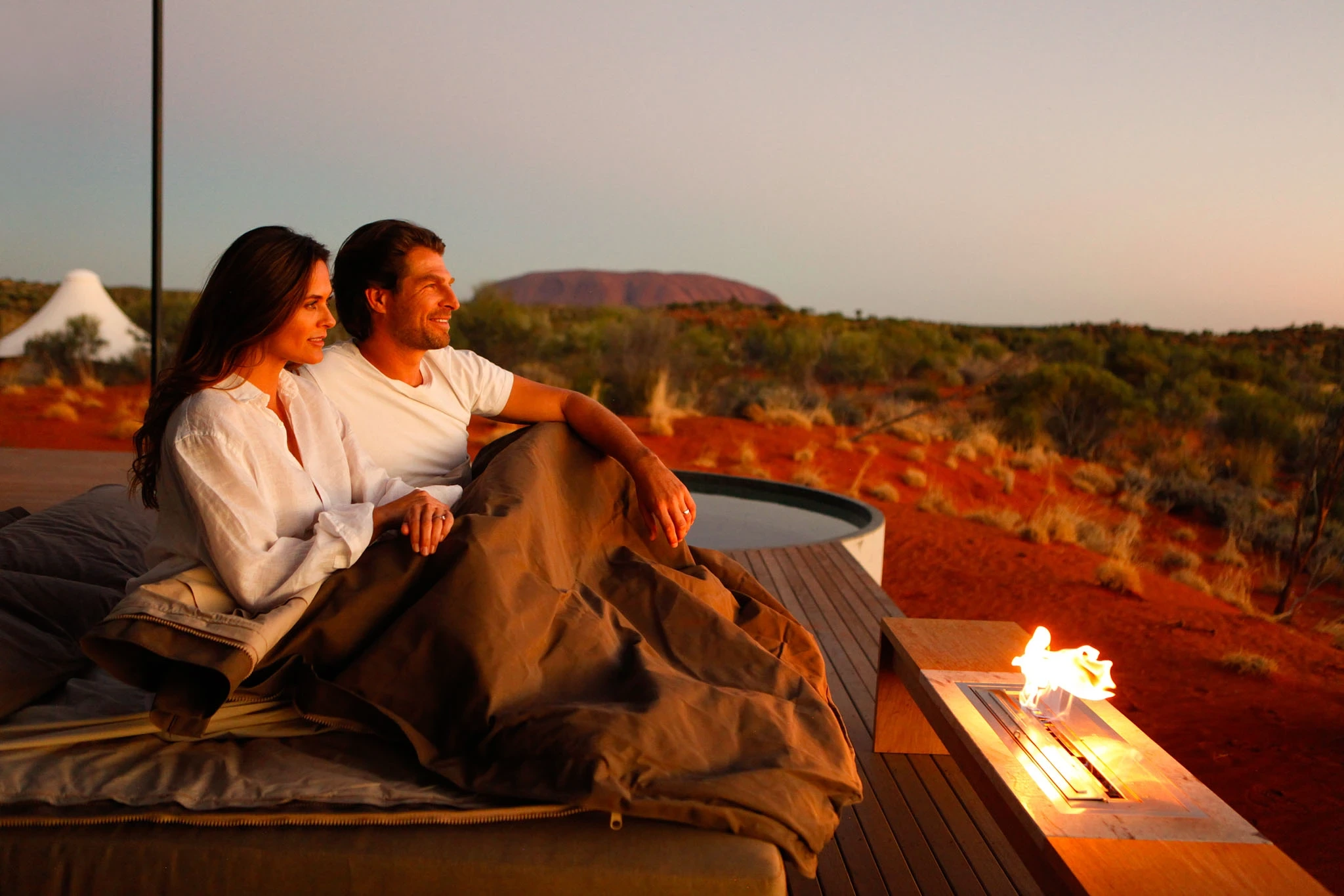 Longitude 131 Dune Pavilion Couple enjoying sunset with Uluru in background